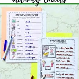 two pages of camping activity sheets with open markers lying over each
