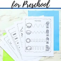 printed weather themed worksheets fanned out over green annd blue paper on a table top