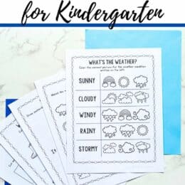 marble table top with dark and light blue pages under fanned out weather themed printables