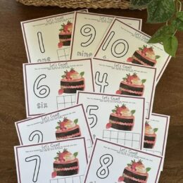 printed and fanned out pages of 10 frame Strawberry Cake themed playdough mats with numbers 1-10
